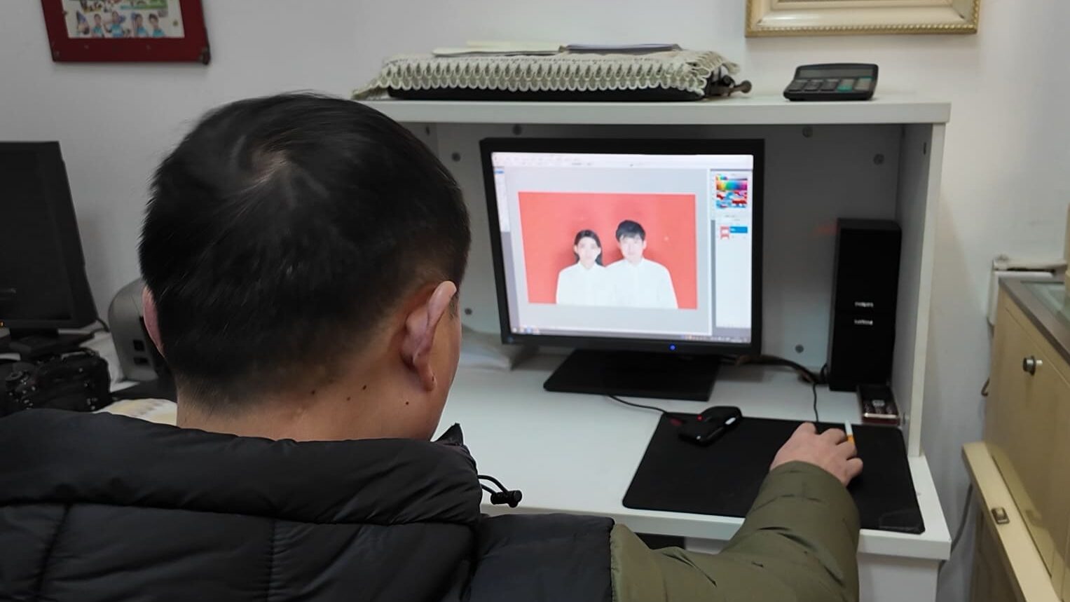 写真館での結婚証写真の編集の様子